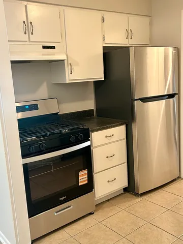 a kitchen with granite countertop white cabinets and black appliances
