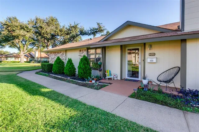 a front view of a house with garden and plants