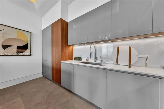 a living room with couches and kitchen view with wooden floor