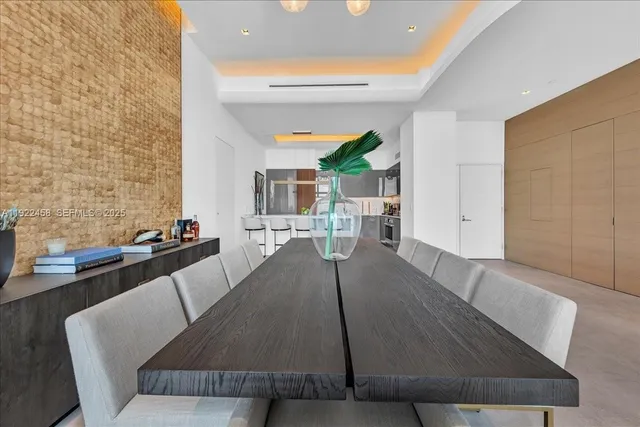 a living room with couches and kitchen view with wooden floor