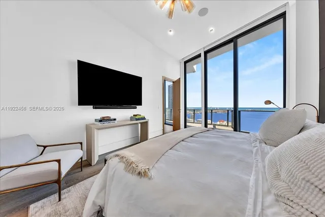 a spacious bedroom with a bed and a flat screen tv