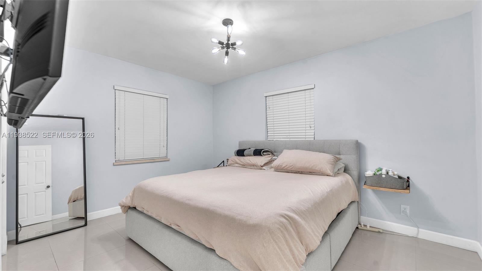 8261 Southwest 27th Street Miami, FL 33155 - Photo 25 of 27 a bedroom with a bed and a chandelier
