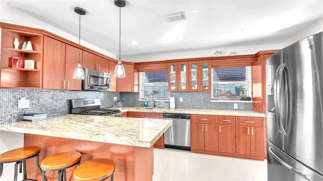 a kitchen with stainless steel appliances granite countertop a sink and wooden cabinets