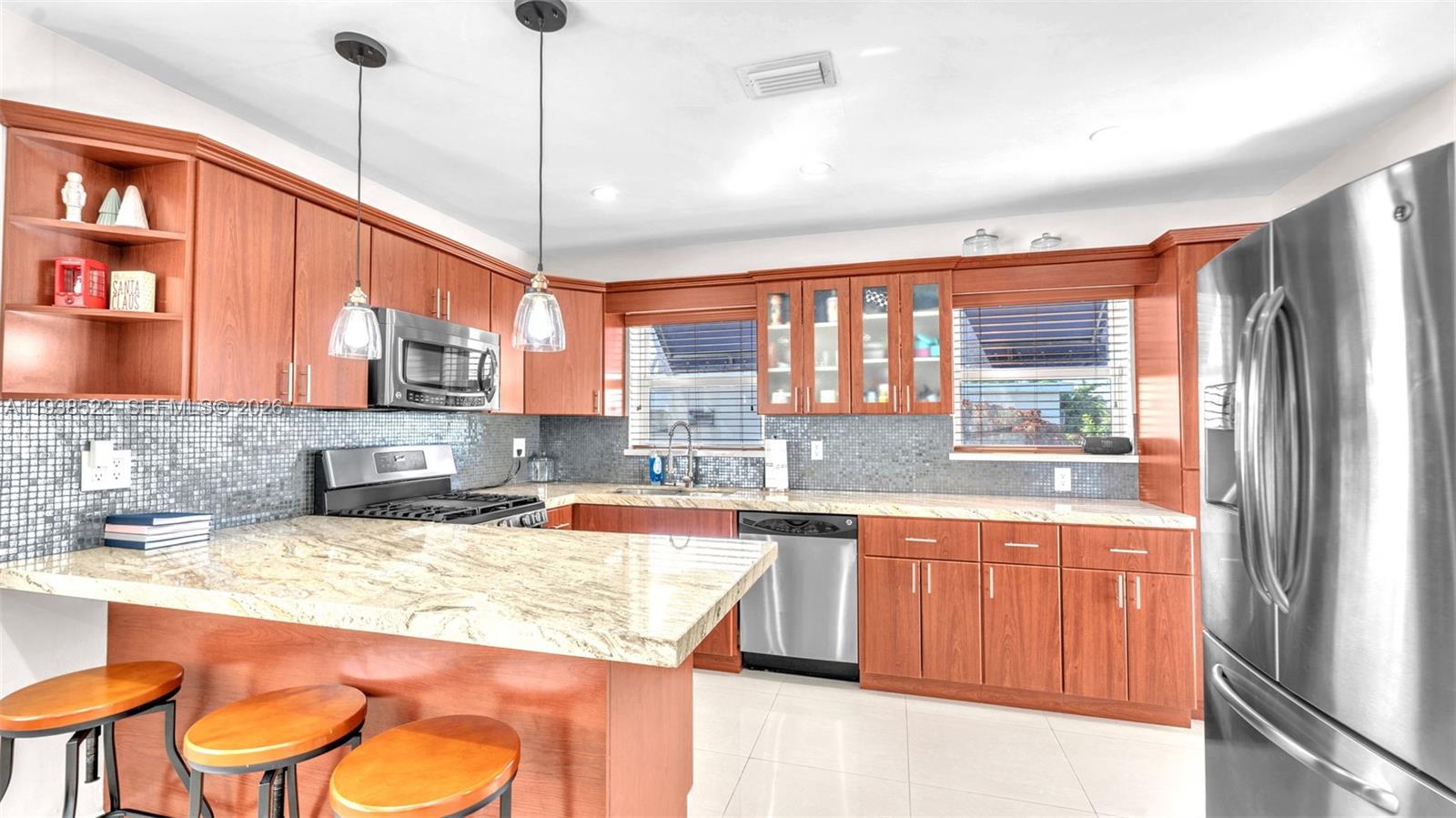 8261 Southwest 27th Street Miami, FL 33155 - Photo 3 of 27 a kitchen with stainless steel appliances granite countertop a sink and wooden cabinets