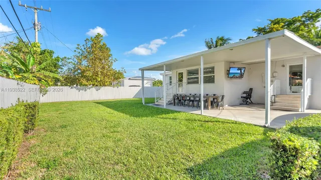 a view of a house with backyard and sitting area