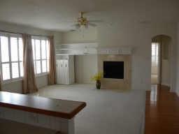 3608 Bent Ridge Drive Plano, TX 75074 - Photo 3 of 16 Unfurnished living room featuring a ceiling fan, arched walkways, and a fireplace