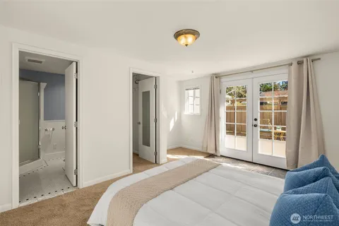 a spacious bedroom with a balcony a bed and a window