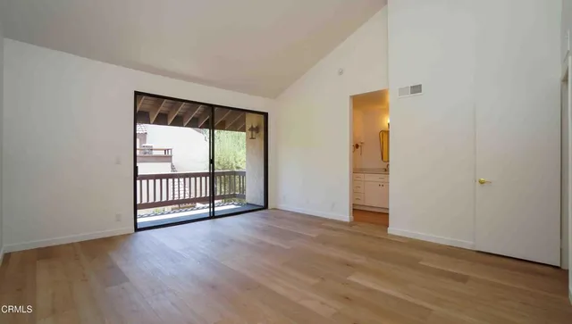 a view of an empty room with wooden floor