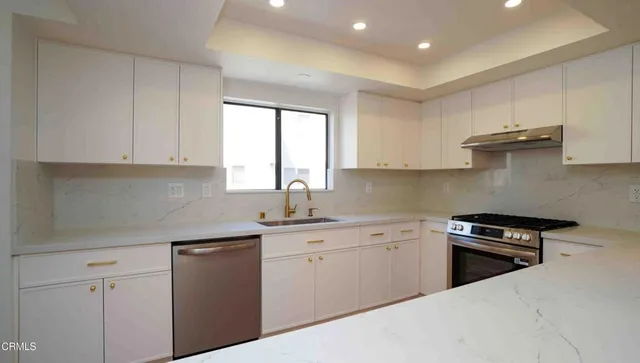 a kitchen with granite countertop white cabinets and white appliances