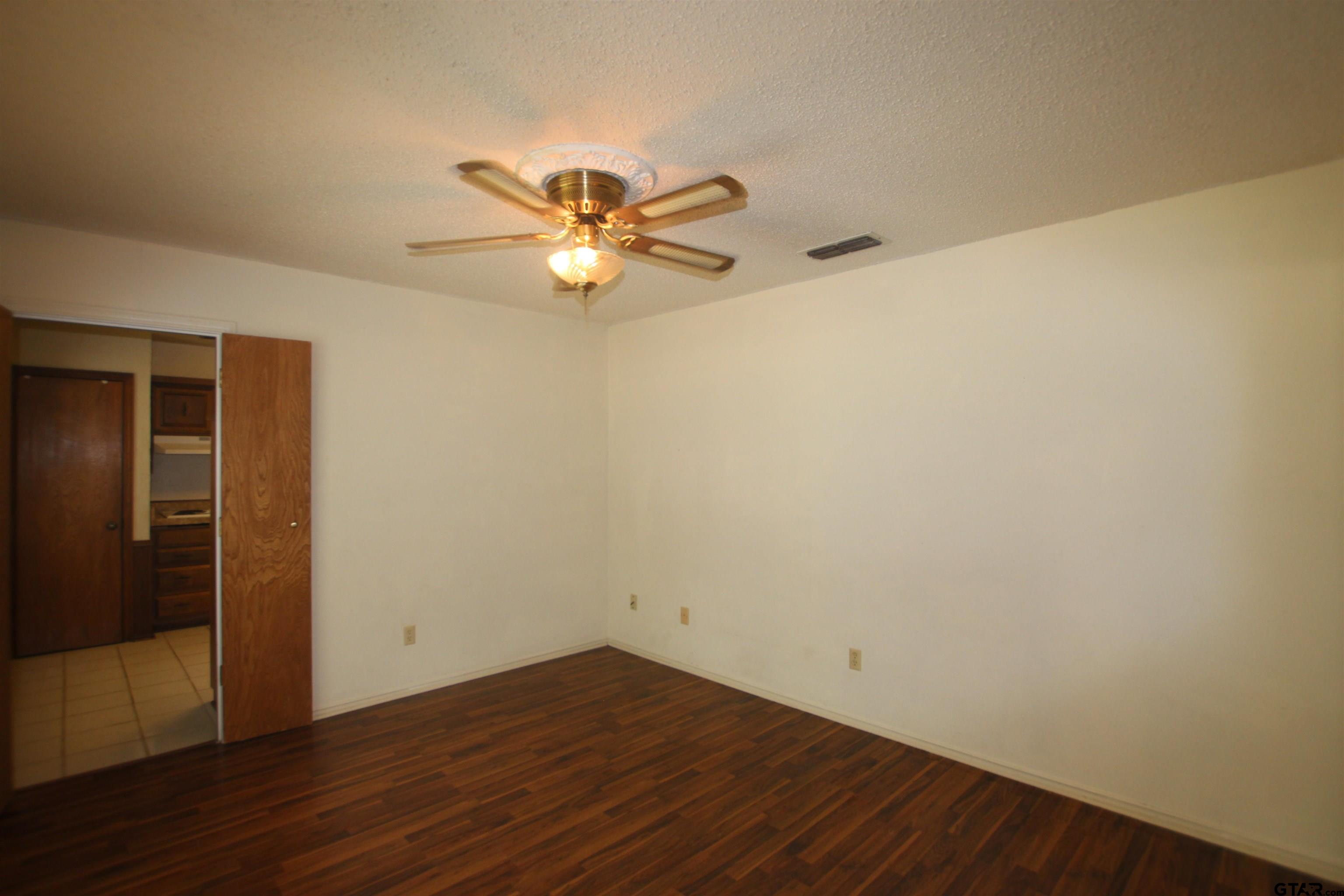 4210 Heather Lane Tyler, TX 75703 - Photo 18 of 27 an empty room with wooden floor and window