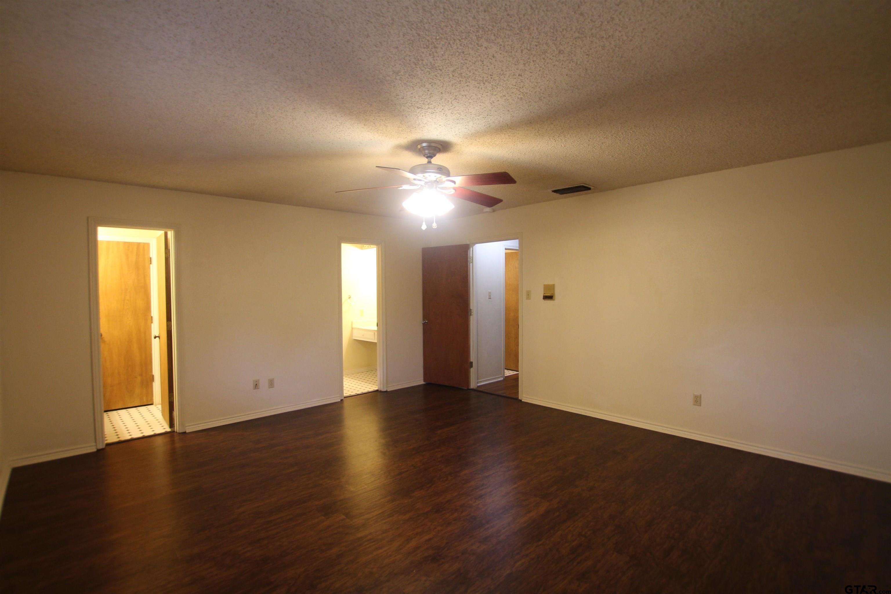 4210 Heather Lane Tyler, TX 75703 - Photo 24 of 27 an empty room with wooden floor and windows