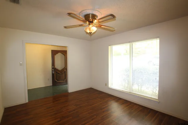 a view of a livingroom with a window and wooden floor