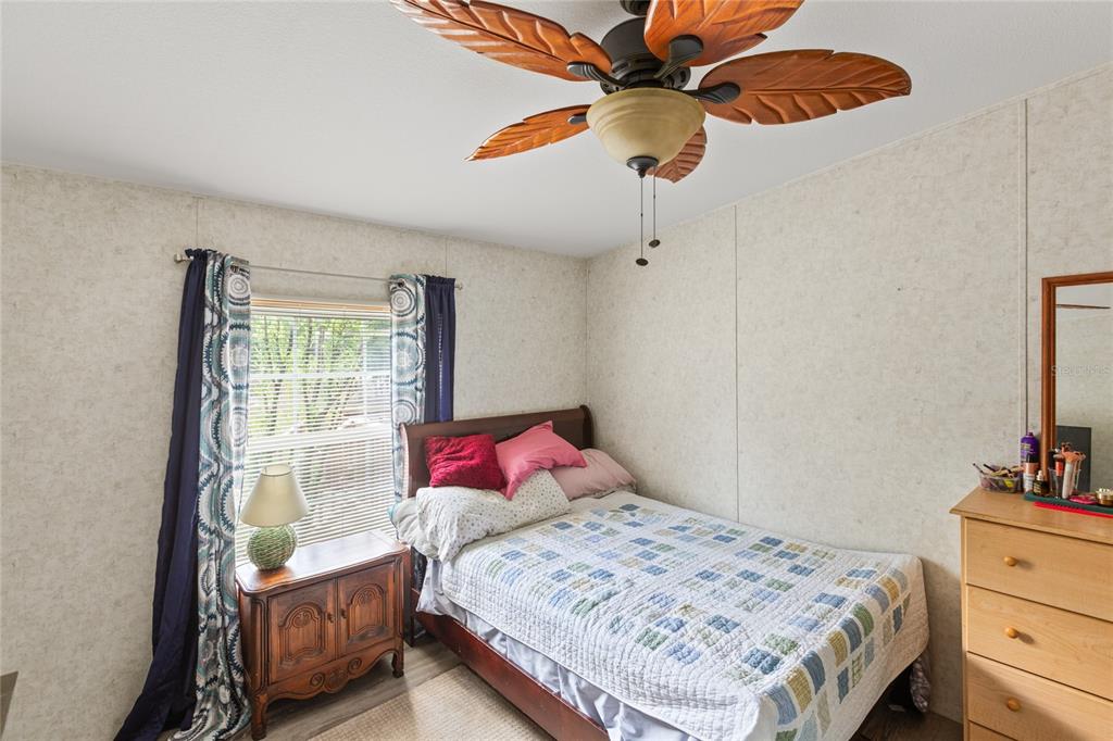 5670 Acadia Street Keystone Heights, FL 32656 - Photo 50 of 65 a bedroom with a bed and a chandelier