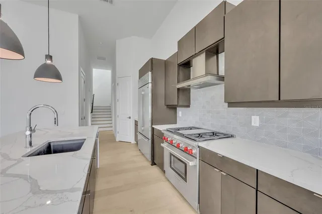 a kitchen with stainless steel appliances granite countertop a sink a stove and a refrigerator