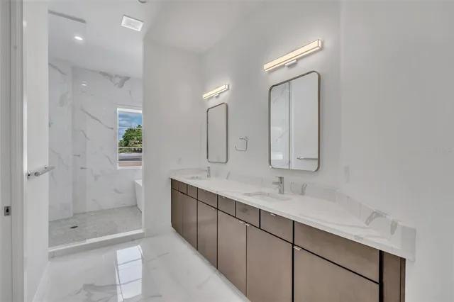a bathroom with a double vanity sink mirror and shower