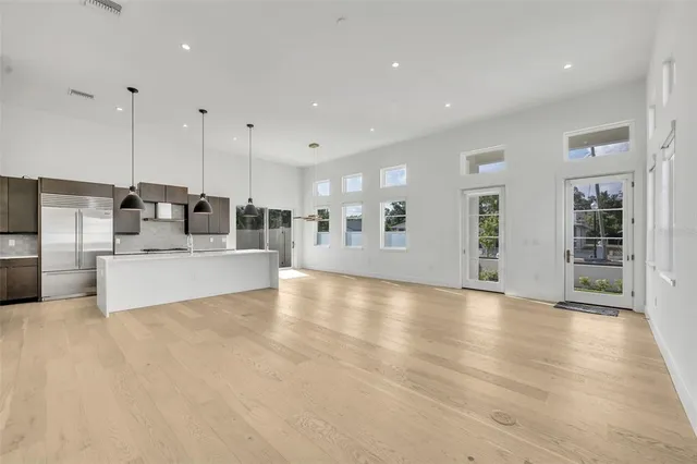 a view of a kitchen with kitchen island a large counter top and stainless steel appliances