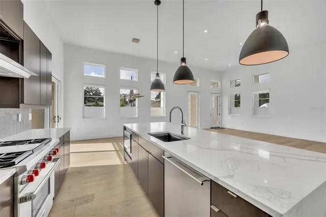 a kitchen with stainless steel appliances granite countertop a sink and a stove