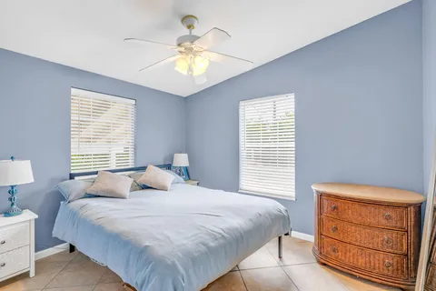 a bedroom with a bed and a lamp on dresser