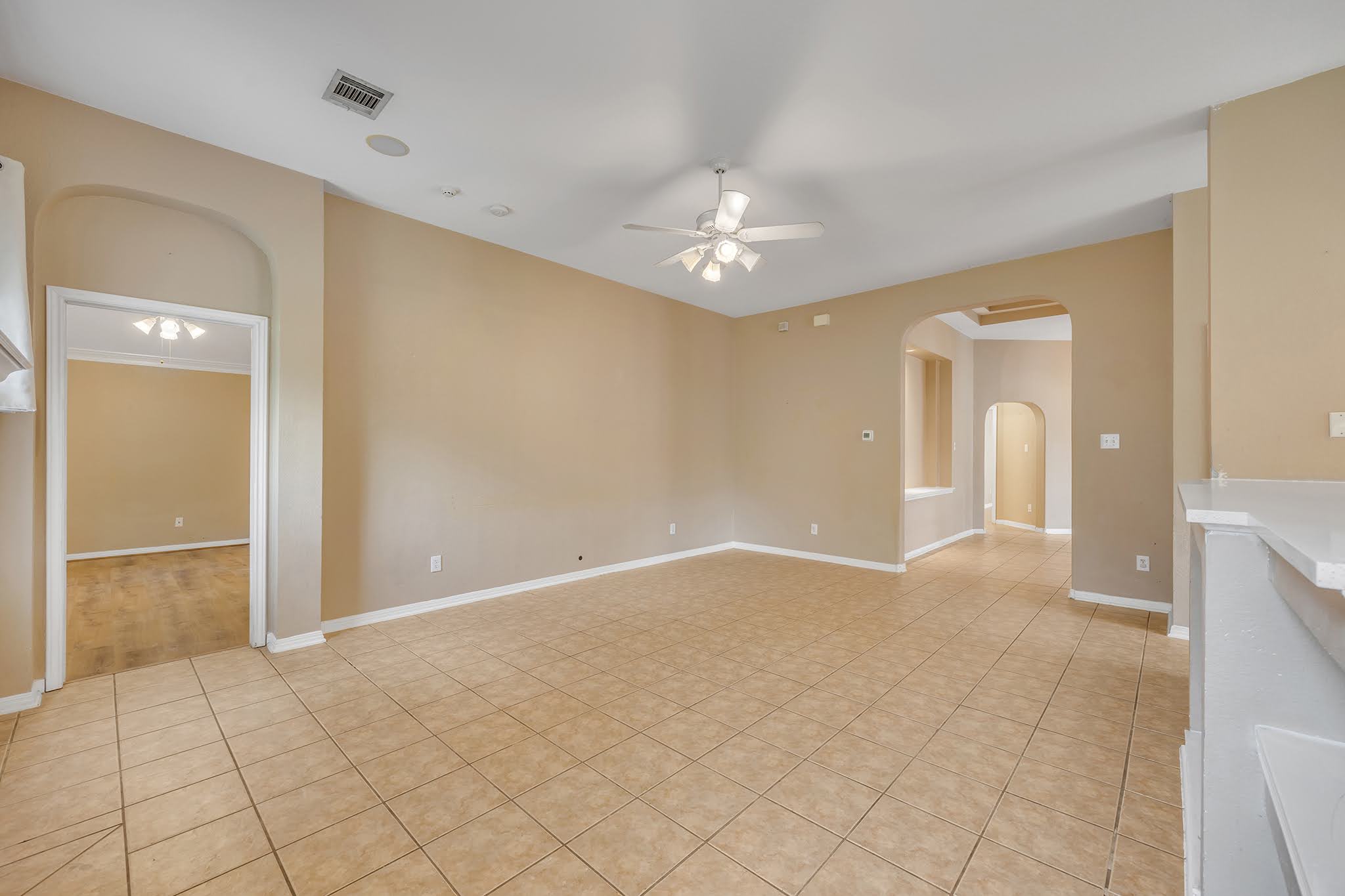 2726 Grimes Ranch Road Austin, TX 78732 - Photo 17 of 35 Spare room with a ceiling fan, arched walkways, and light tile patterned floors