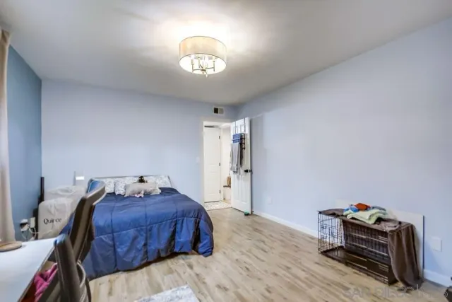 a spacious bedroom with a bed and a chandelier