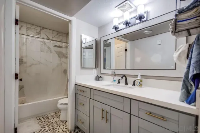 a bathroom with a sink a toilet and shower a mirror