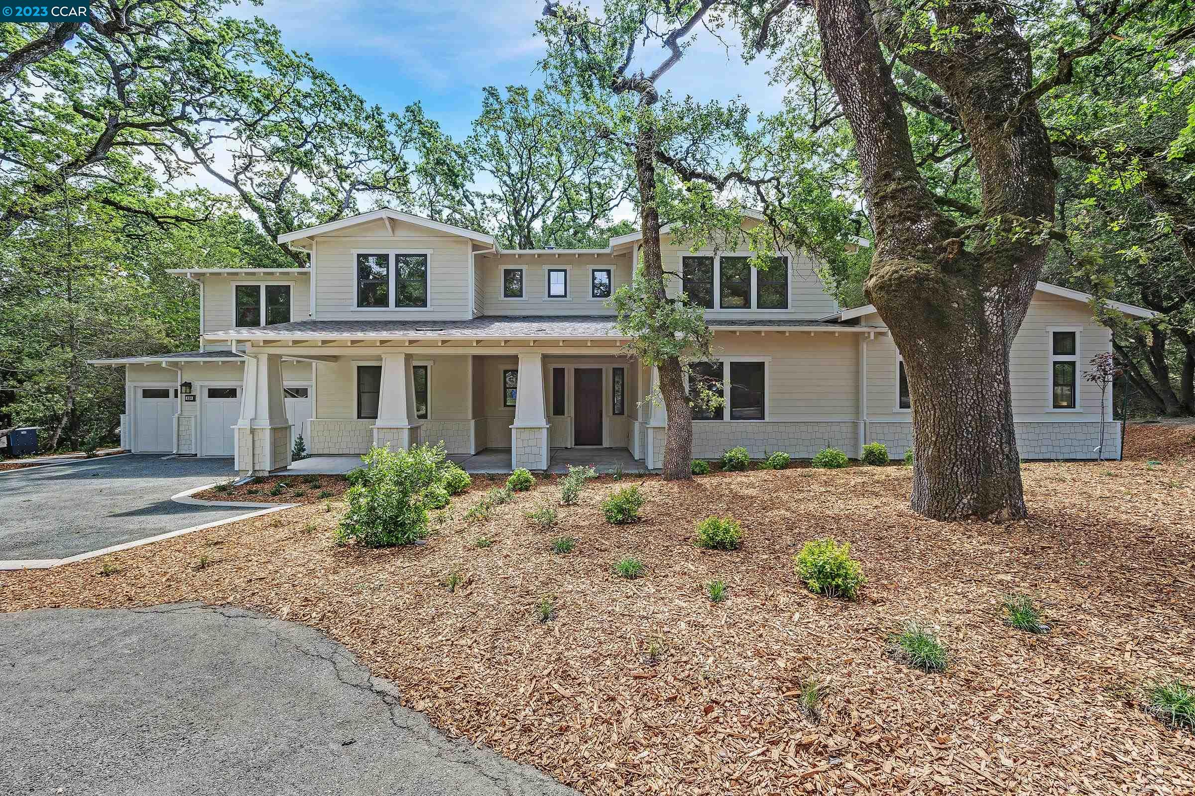a front view of a house with a tree