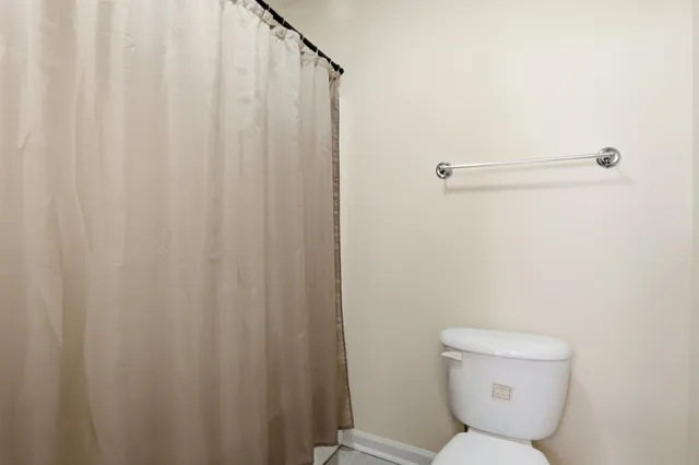 a bathroom with a toilet and a shower curtain