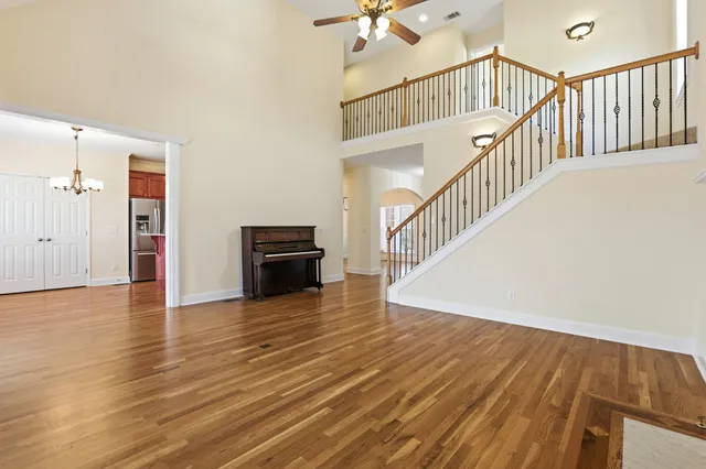 a view of a hallway with wooden floor and staircase