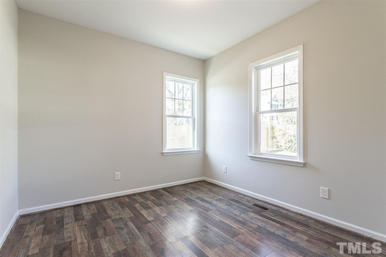 805 Bragg Street Raleigh, NC 27610 - Photo 22 of 26 an empty room with wooden floor and windows