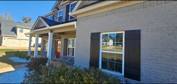 a view of a house with large windows and plants