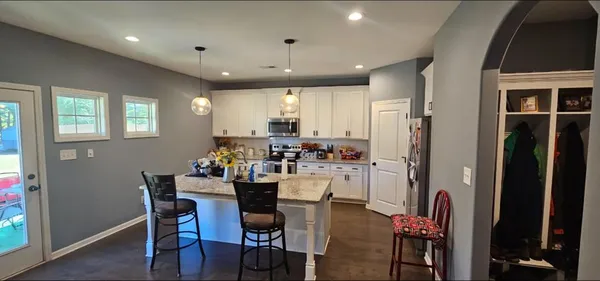 a kitchen with a dining table chairs refrigerator and cabinets