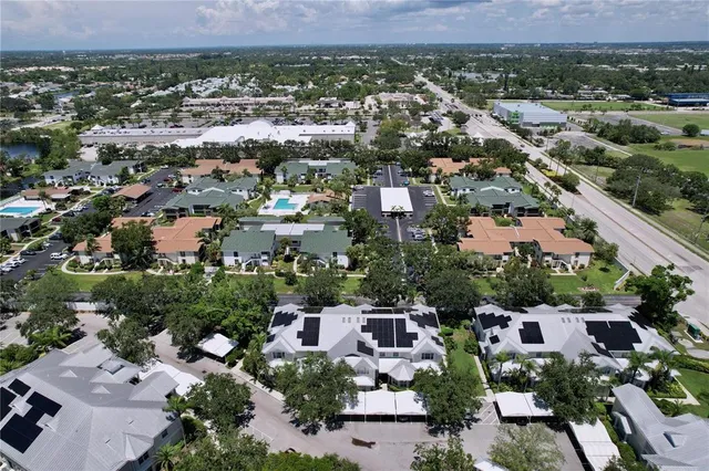 an aerial view of a house with garden space and trees in the back