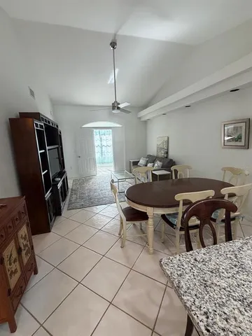 a living room with furniture a dining table and chairs with wooden floor