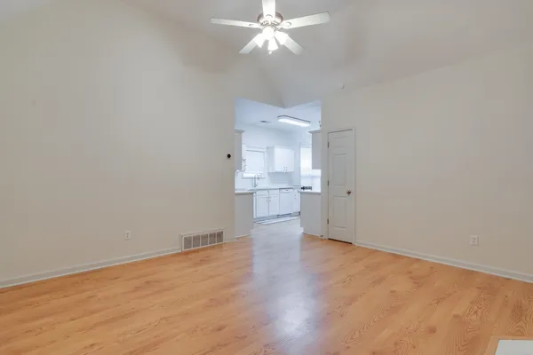 a view of a kitchen with wooden floor and a ceiling fan