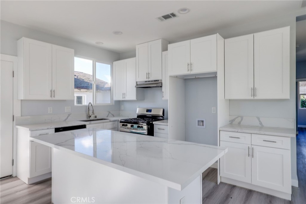 11875 Wisteria Avenue, Unit ADU Fountain Valley, CA 92708 - Photo 4 of 14 a kitchen with white cabinets and white appliances