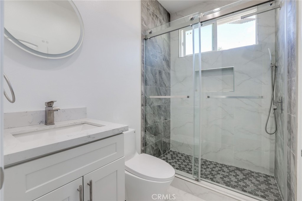 11875 Wisteria Avenue, Unit ADU Fountain Valley, CA 92708 - Photo 8 of 14 a bathroom with a granite countertop sink a toilet and a mirror