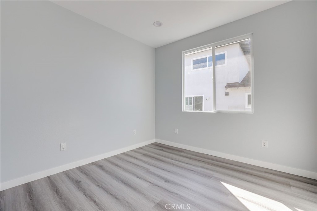 11875 Wisteria Avenue, Unit ADU Fountain Valley, CA 92708 - Photo 9 of 14 an empty room with wooden floor and windows