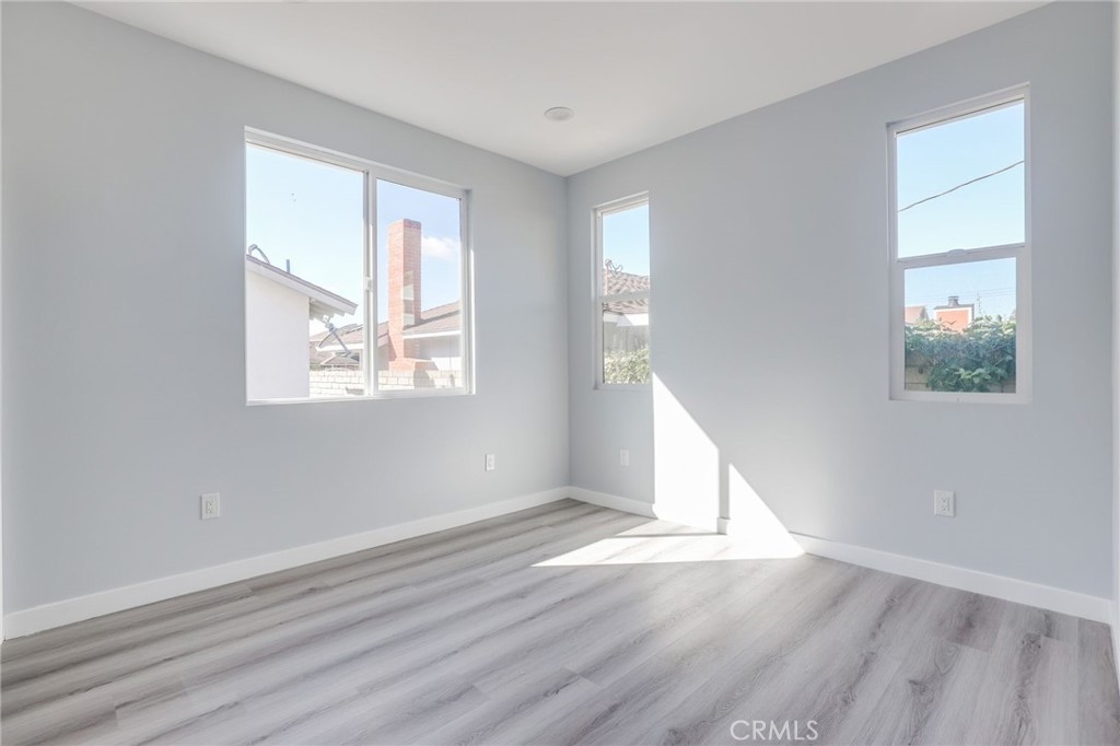 11875 Wisteria Avenue, Unit ADU Fountain Valley, CA 92708 - Photo 10 of 14 an empty room with wooden floor and windows
