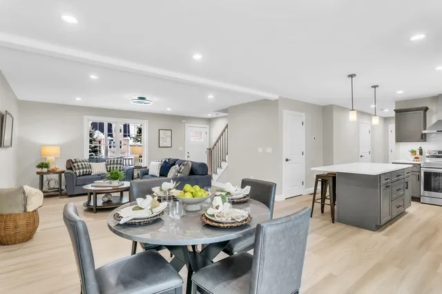 a living room with furniture kitchen view and a wooden floor