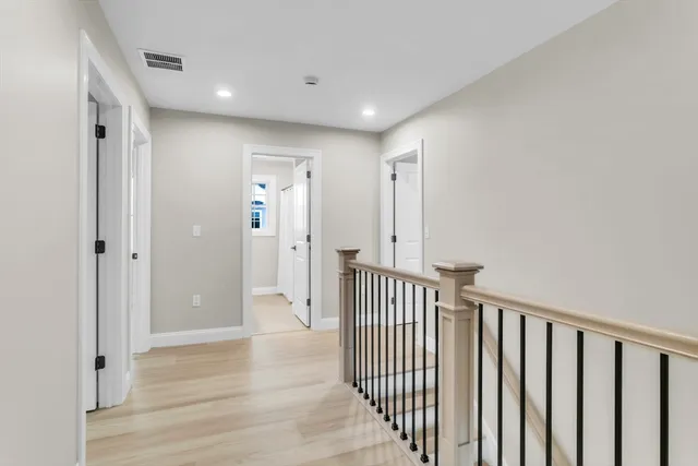 a view of a hallway with wooden floor and entryway
