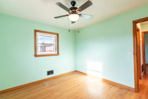 a view of a big room with wooden floor and a ceiling fan