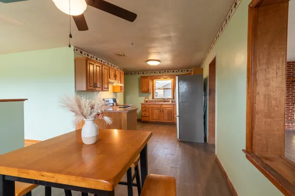 a view of a dining room and livingroom with furniture wooden floor a chandelier