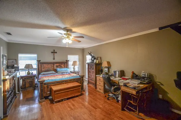 a bedroom with furniture a window and a ceiling fan
