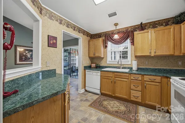 a kitchen with granite countertop a sink and a stove