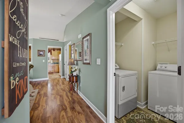 a view of a hallway and a room with wooden floor