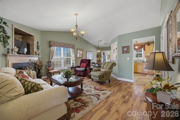a living room with furniture chandelier and a flat screen tv