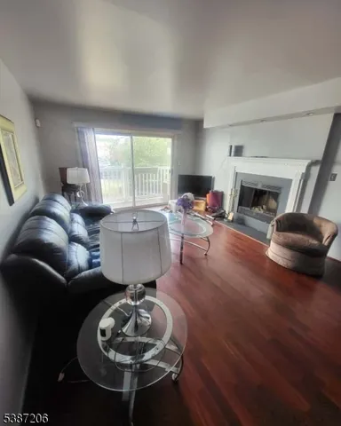 a living room with furniture a fireplace a rug and a large window