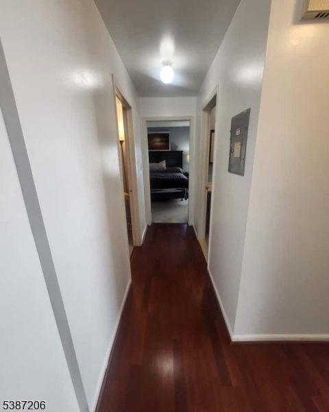 1203 Jesse Way Piscataway, NJ 08854 - Photo 4 of 12 a view of a hallway to an empty room with wooden floor
