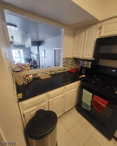 a kitchen with granite countertop a sink a stove and cabinets