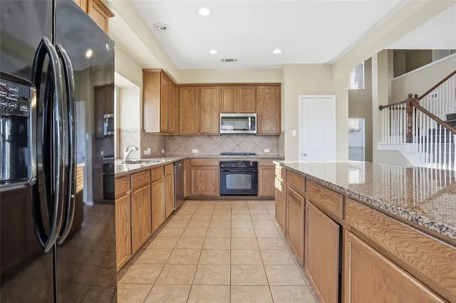 a large kitchen with stainless steel appliances lots of counter top space cabinets and a kitchen